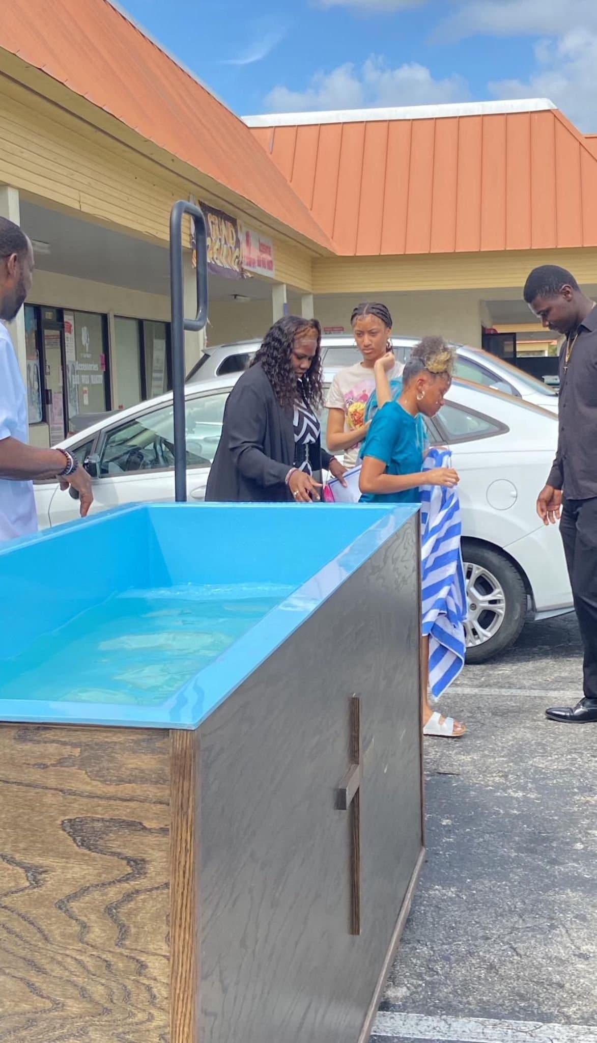 Members of See His Face Ministries gathered around the baptismal tank outside the church in Fort Myers