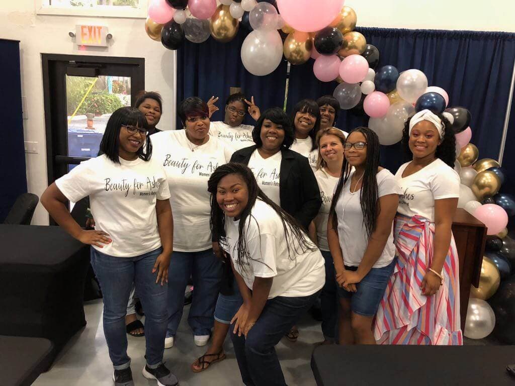 Women of See His Face Ministries gathered together at a women's ministry event, wearing matching shirts