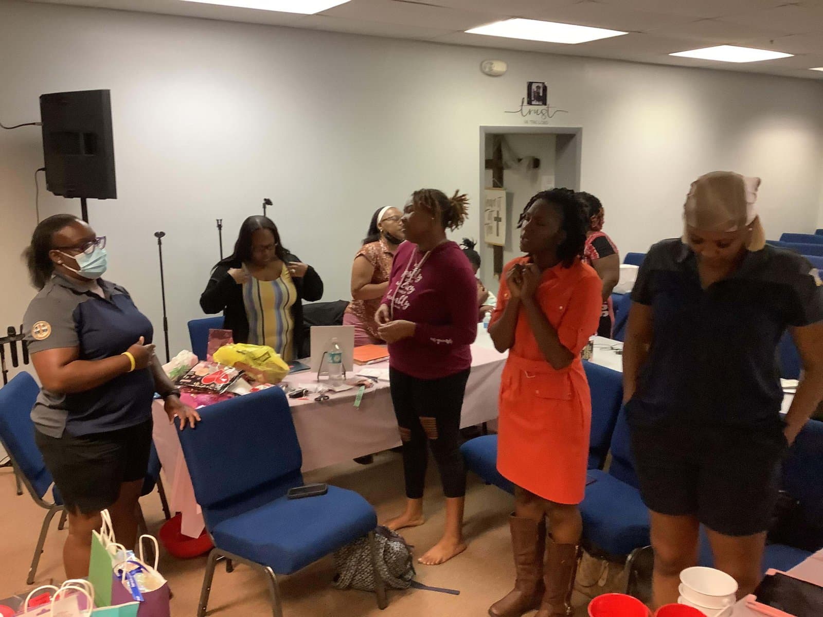 Women of See His Face Ministries standing together in prayer at a gathering